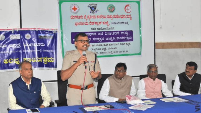 A police officer addresses the accident-prevention awareness programme organised with IRCS Bangalore South Taluk